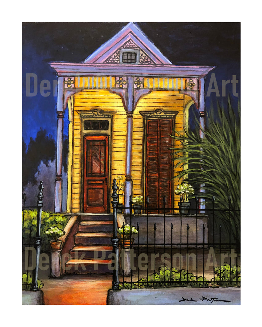 A print of a shotgun house in New Orleans with a dim lit night background. The house features a yellow front and a black wrought iron fence with flowers.